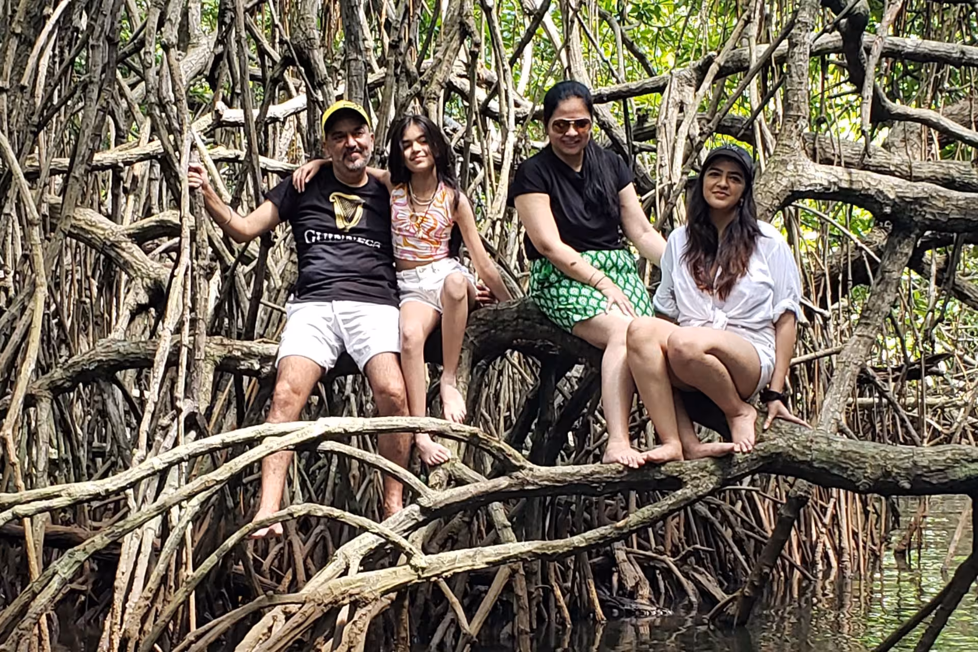 Family posing on mangrove roots during Bentota River Safari, exploring Sri Lanka’s lush wetlands