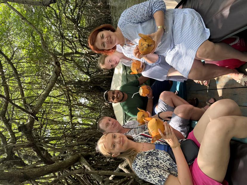 Guests sipping fresh king coconut on Bentota River mangrove safari boat, a top Sri Lanka river cruise
