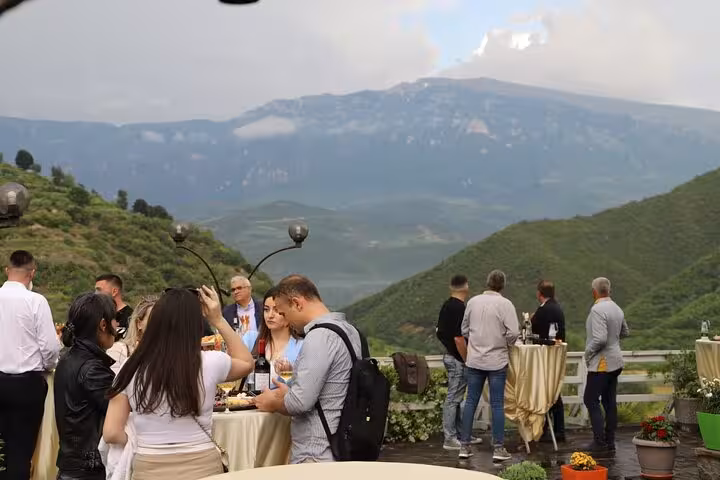 People enjoying wine tasting with scenic mountain views on the Berat 4x4 off-road vineyard tour.