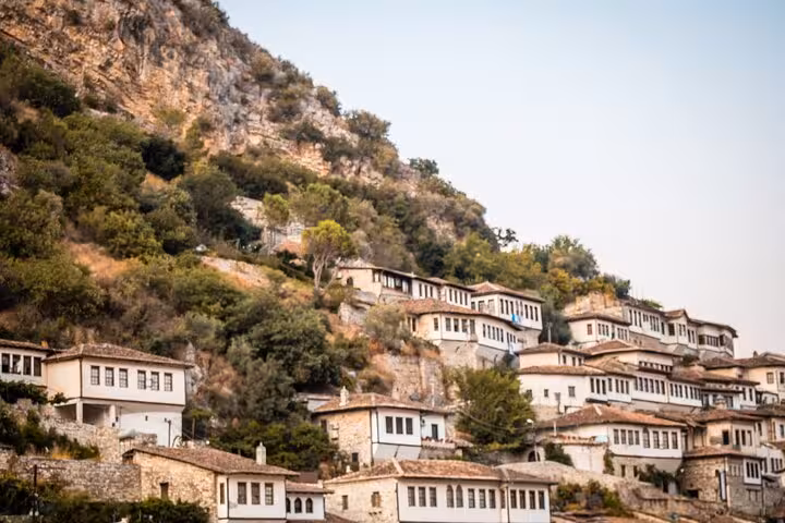 Discover the charming hillside cityscape of Berat, Albania, known for its historic white Ottoman houses.