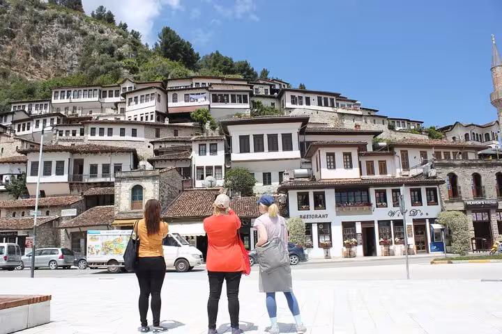 Tourists admire the traditional Ottoman architecture of Berat, a UNESCO World Heritage site in Albania's charming landscape.
