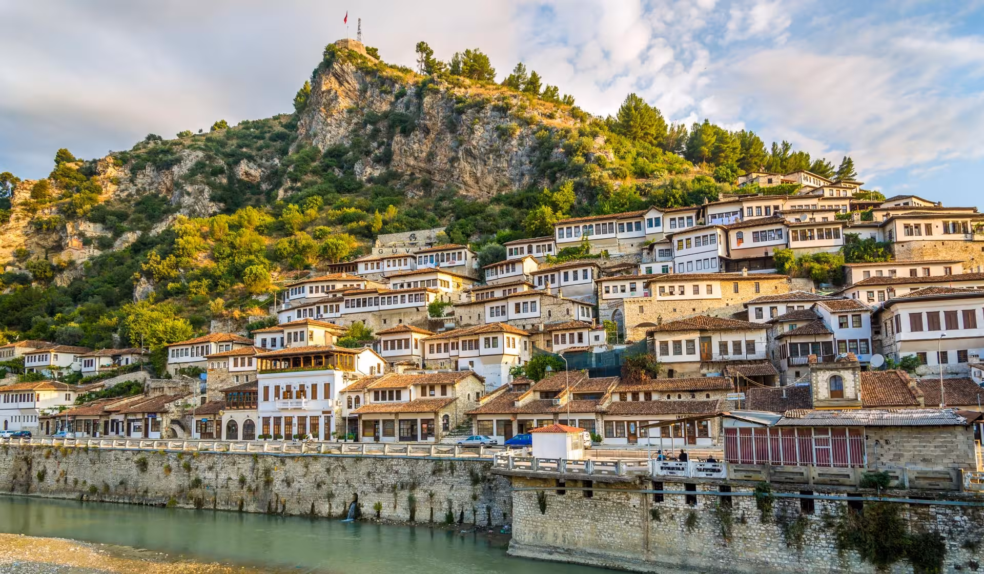 Scenic view of Berat's hillside Ottoman architecture and the Osum River, showcasing Albania's cultural heritage.