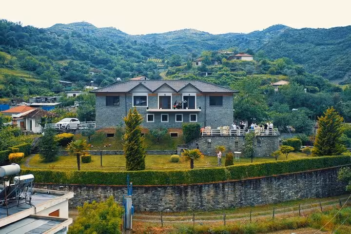 Stone house set amidst rolling hills and vineyards in Berat, ideal for off-road adventure and wine tasting.