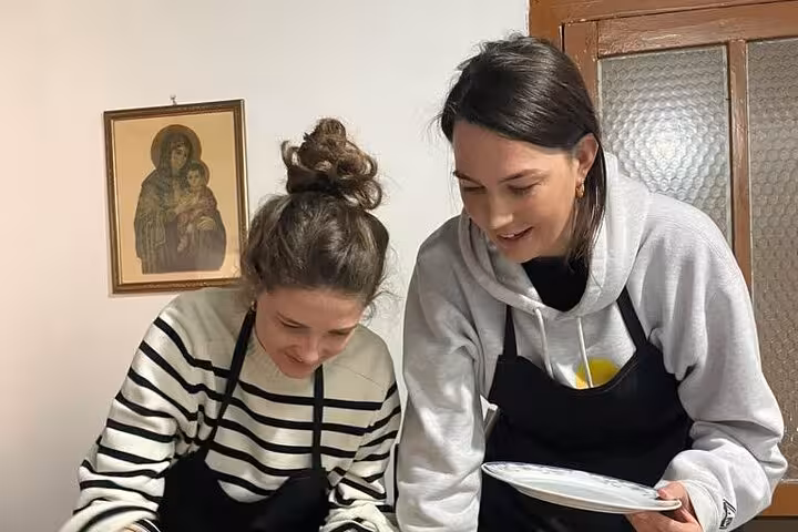 Participants engaging in a hands-on cooking session at a traditional Albanian cooking class in Berat.
