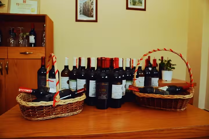 Assorted wine bottles displayed on a wooden table, highlighting the vineyard experience in Berat 4x4 tour.