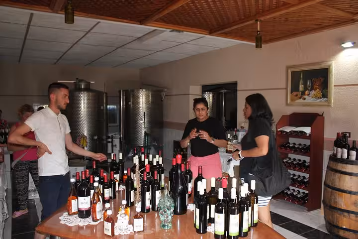 Guests sample a variety of wines in a cozy indoor tasting room in Berat on the Grand Wine Tasting & Food Tour.
