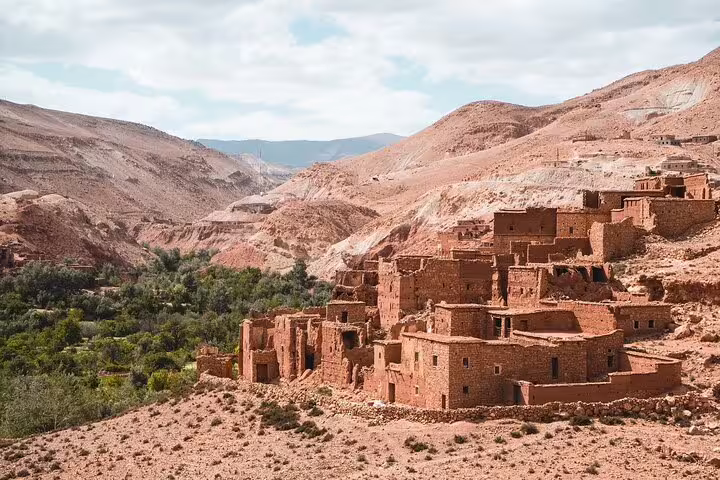 Berber kasbah village above a green oasis valley, Atlas Mountains stop on Morocco 11-day Sahara tour from Casablanca