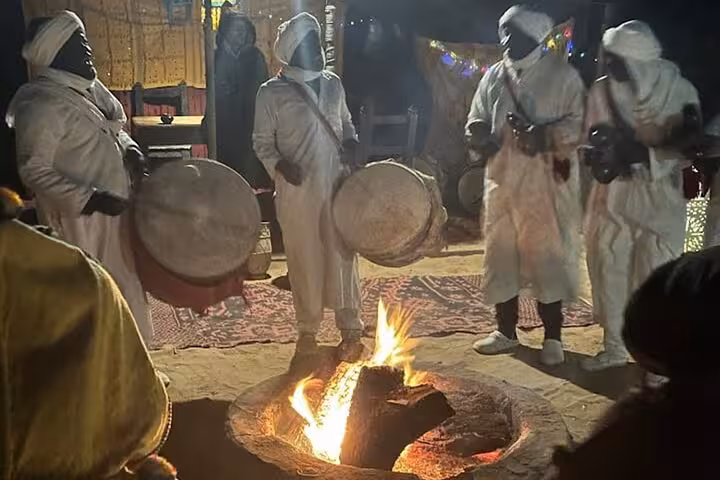 Traditional Berber musicians performing around a campfire at night during the 3-day Marrakech to Fes desert tour.