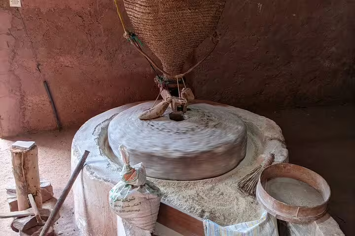 Traditional Berber stone mill grinding grain in Ourika Valley, Atlas Mountains day trip cultural stop