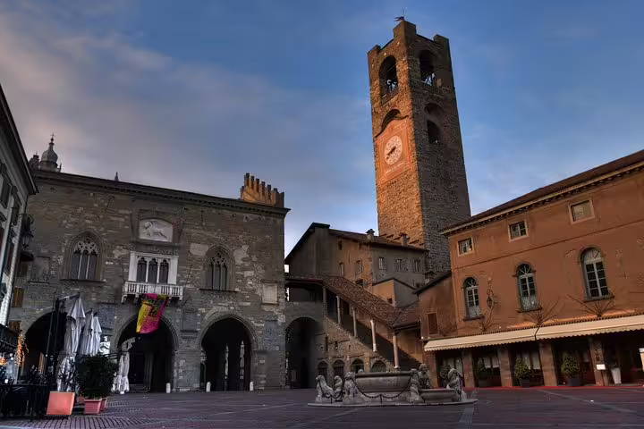 Evening view of Piazza Vecchia and Civic Tower in Bergamo Alta, featured on a 2.5-hour private Bergamo walking tour