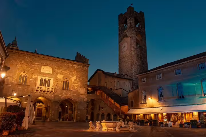 Piazza Vecchia at dusk with Torre Civica in Bergamo Old Town, highlight on self-guided scavenger hunt