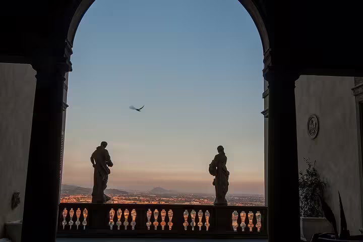 Sunset view from Bergamo Old Town archway with statues, a key stop on the self-guided scavenger hunt tour