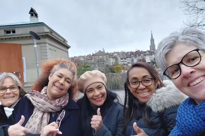 Smiling travelers selfie with Bern Old Town skyline on Bern scavenger hunt and sights self-guided walking tour