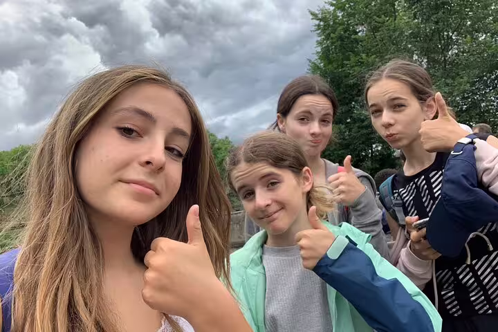 Group selfie giving thumbs up during Bern scavenger hunt and sights self-guided tour, outdoor city adventure