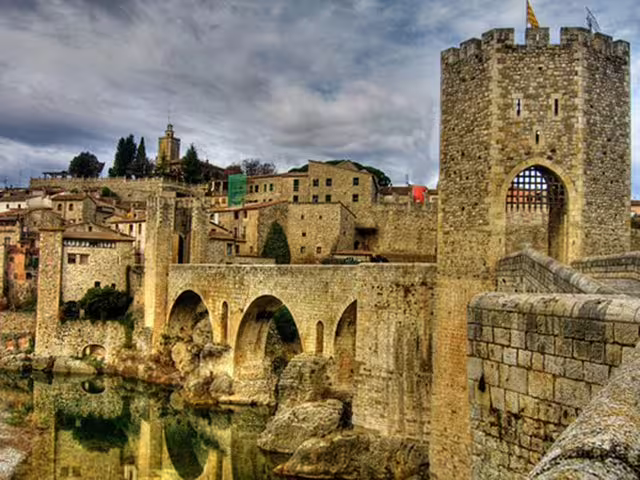Explore the stunning medieval architecture of Besalú, Catalonia, featuring ancient stone bridges and charming village views.