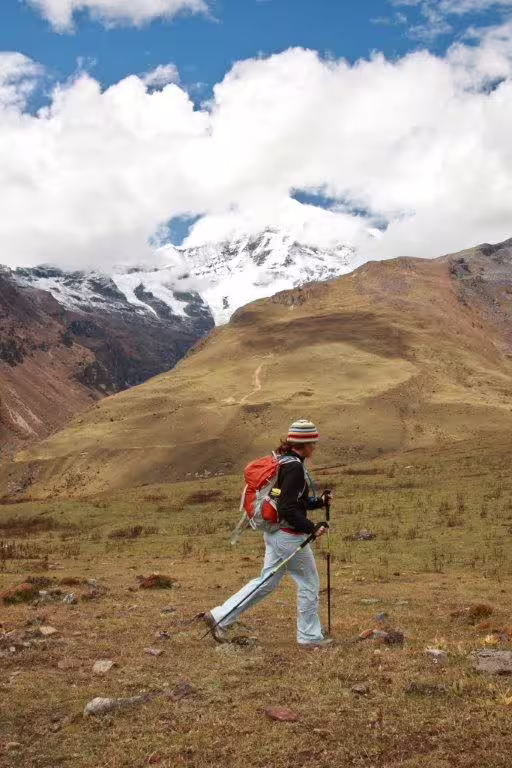 Hiker trekking through Bhutan's scenic mountains with snow-capped peaks, ideal for a 10-day adventure tour.