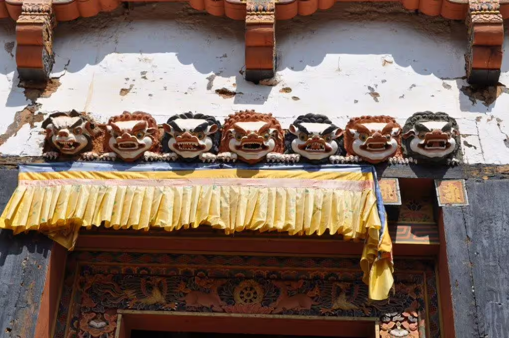 Intricate Bhutanese temple carvings with vibrant colors, highlighting traditional architecture on an 8-day tour.
