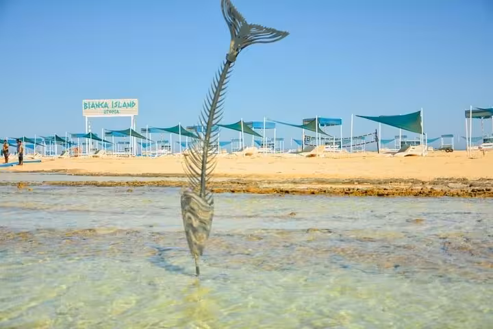 Bianca Island beach in Hurghada with shade tents and shallow lagoon, Utopia island tour with lunch and transfer
