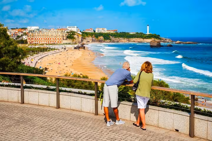 Couple enjoying panoramic view of Biarritz beach and lighthouse on a sunny day, ideal for a guided city walk.