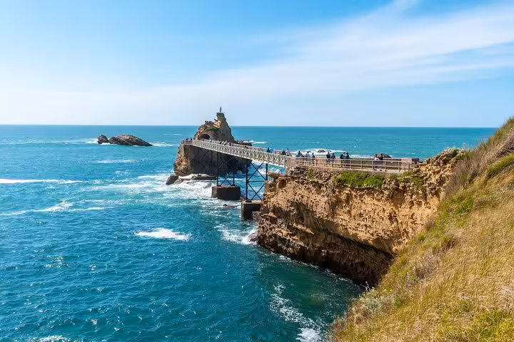 Scenic promenade leading to the iconic Rocher de la Vierge, surrounded by turquoise waters in Biarritz, ideal for walking tours.