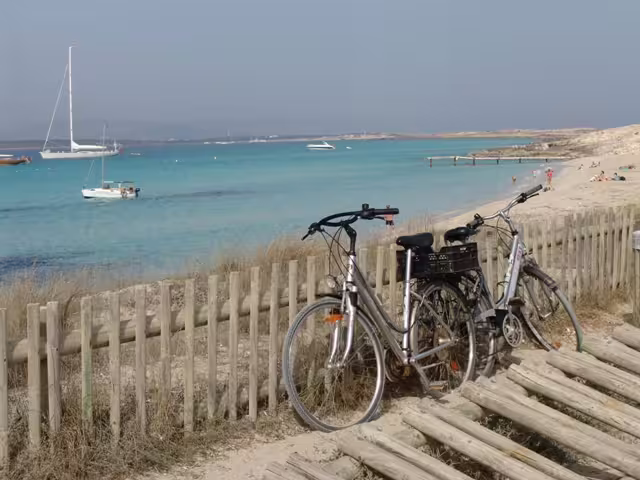 Bicycles by coastal fence in Formentera, Ibiza day trip bike tour with transfer and ferry to beaches