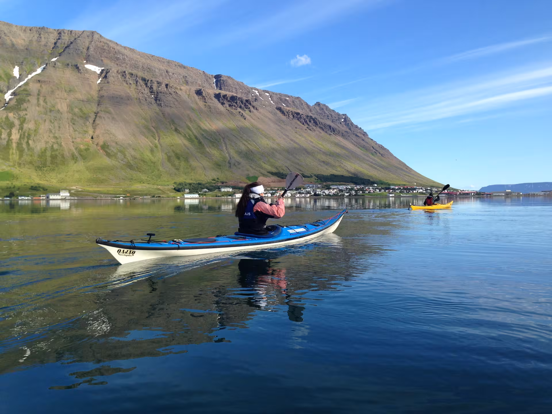 Guided sea kayaking on a calm fjord with mountain views, part of a Bike and Kayak Combo adventure tour