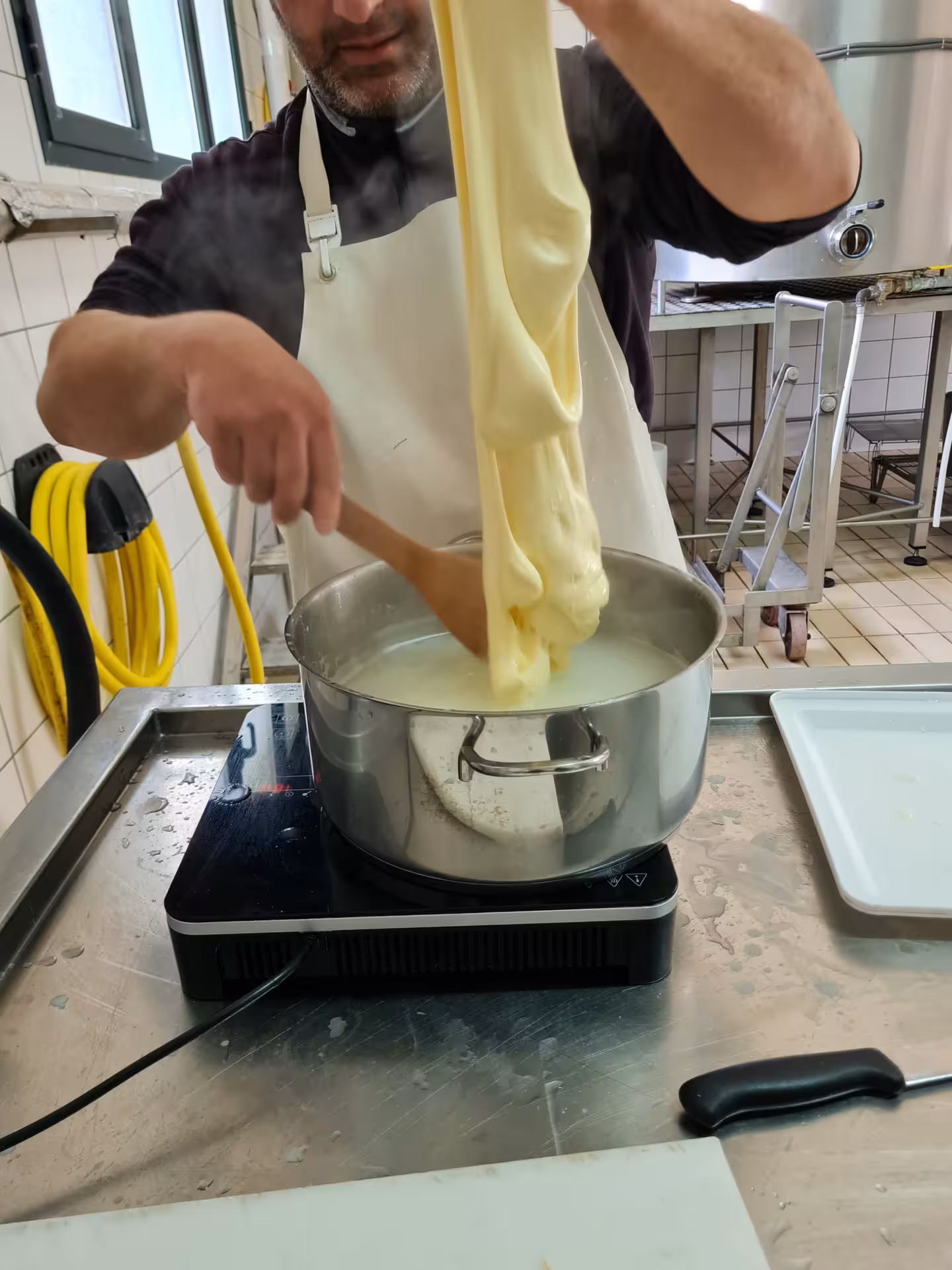 Stretching cheese in Bitti, Sardinia on a shepherd's day tour, highlighting traditional cheese-making with local expertise.