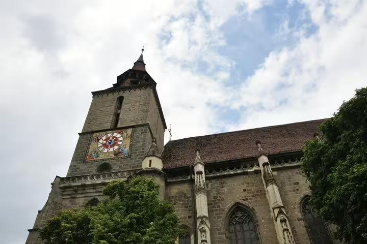 Black Church Gothic tower with ornate clock face in Brasov Old Town, Romania