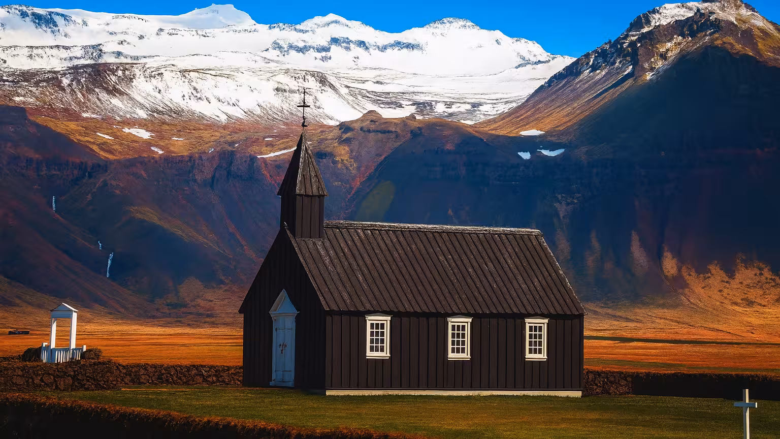 Historic black church stands against stunning Icelandic mountains, a highlight on the Golden Circle Private Tour.