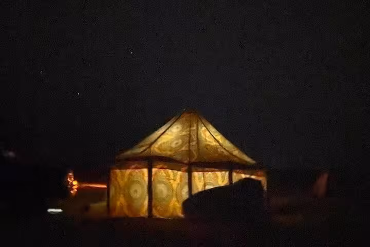 Illuminated desert tent camp at night during private 2-day Black and White Desert camping tour in Egypt