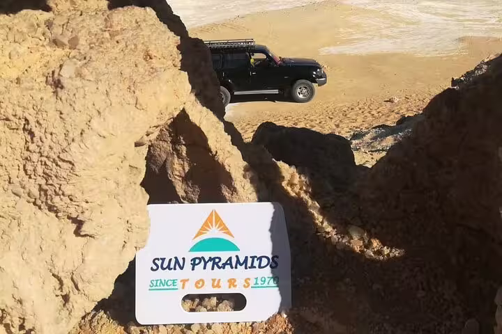 Sun Pyramids sign with 4x4 jeep in background, Egypt Black & White Desert 2-day adventure tour and camping
