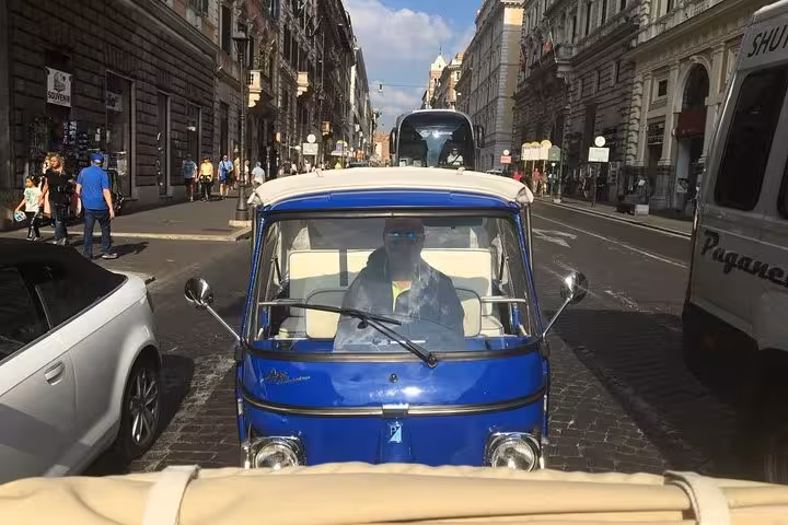 Blue Ape Calessino navigating a bustling city street as part of the exciting James Bond tour.