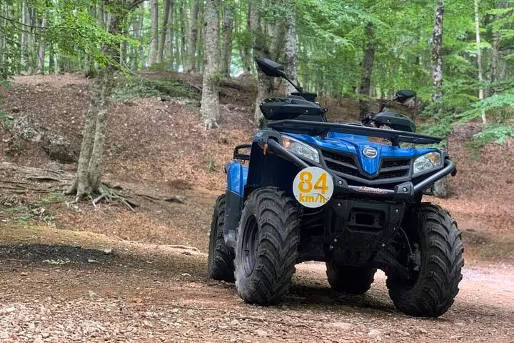 Blue ATV parked on a forest trail, ready for an off-road adventure on Mount Faito from Sorrento.