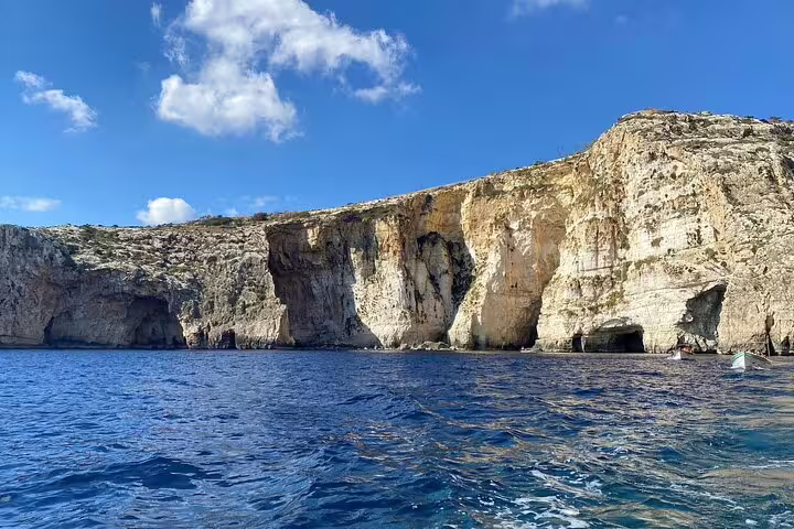 Breathtaking coastal cliffs of Malta's Blue Grotto under a clear blue sky, perfect for scenic boat tours and photography.