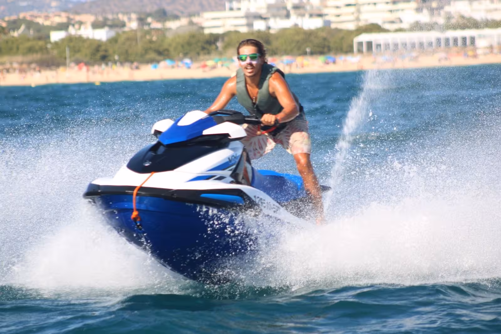 Rider carving sharp turns on a blue jet ski off Praia dos Tomates beach, showcasing exciting Algarve jet ski rental experience