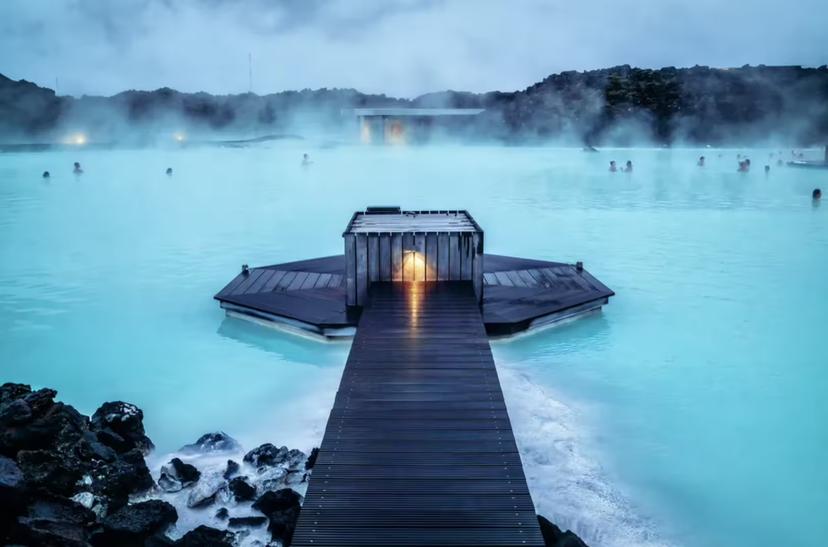 Blue Lagoon geothermal spa with steaming milky-blue waters, wooden boardwalk, and floating sauna in Iceland