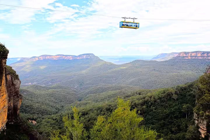 Blue Mountains cable car gliding above lush valleys, offering panoramic views on a private tour adventure.
