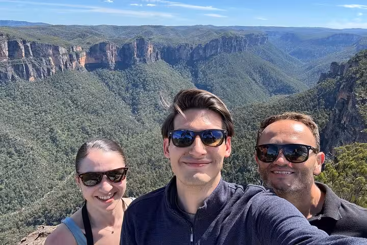 Group enjoying breathtaking views of the Blue Mountains' cliffs and valleys on a private guided tour.