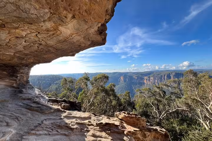 Stunning rock formations frame expansive vistas of the Blue Mountains, ideal for a winery tasting tour.