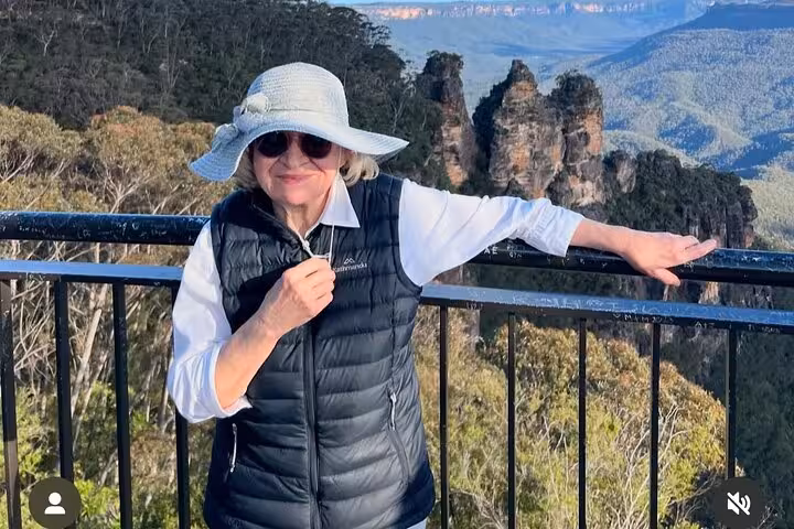 Tourist posing at the Three Sisters lookout in the Blue Mountains on a private tour, highlighting hidden gems.