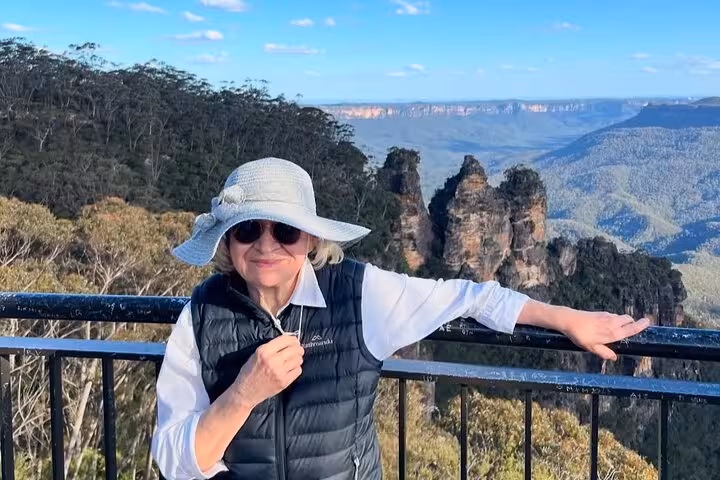 Woman in sunhat enjoying the stunning view of the Three Sisters rock formation in the Blue Mountains.