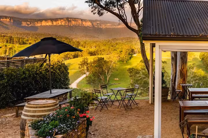 Charming outdoor seating with vineyard views in Blue Mountains winery at sunset.