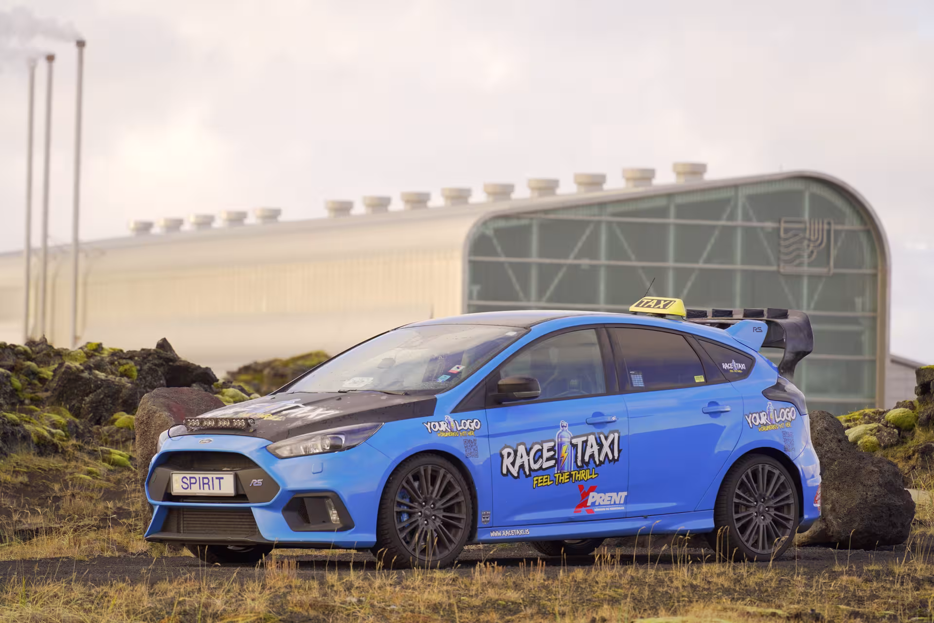 Blue rally car for Glacier Lagoon private rally car adventure in Iceland, parked on lava field near hangar
