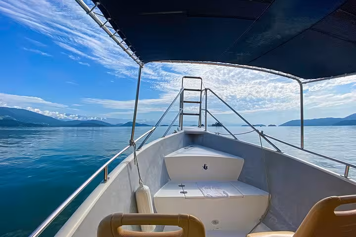 Boat cruising on tranquil waters with stunning views of Peak Sugar Bread, perfect for adventure and exploration.