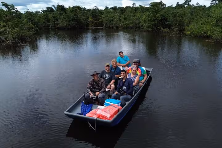 Group enjoying a scenic boat safari on Rio Frio surrounded by lush greenery and calm waters.
