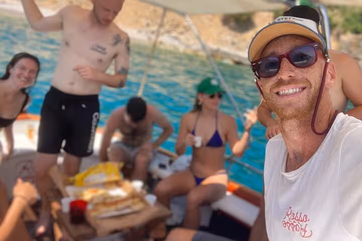 Group enjoying a lively boat tour from La Spezia to Portovenere with snacks and ocean views.