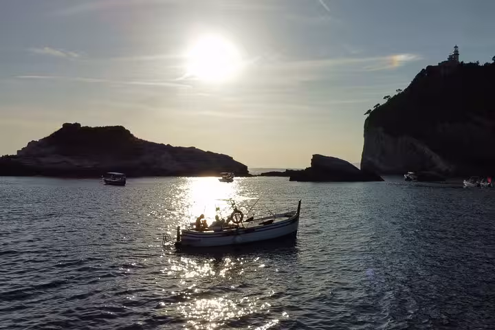 A scenic boat ride at sunset in La Spezia, showcasing stunning silhouettes of coastal cliffs and serene waters.
