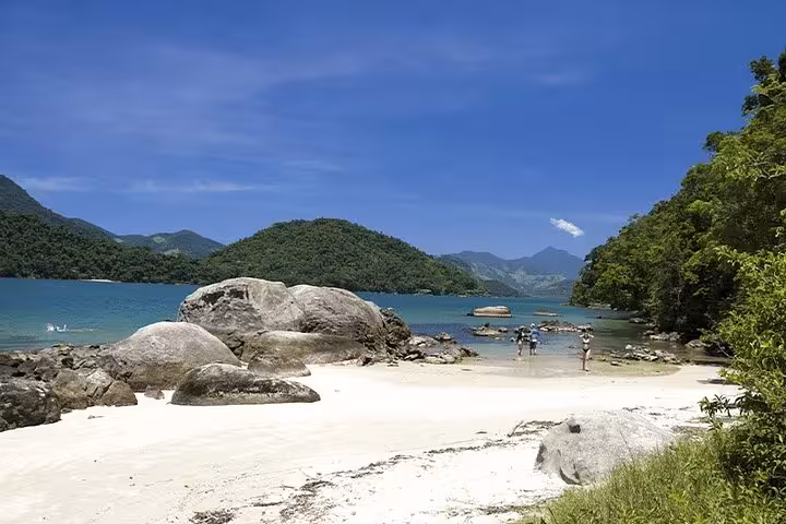 Pristine beach with clear waters and lush green hills in Paraty, Brazil, ideal for a boat tour adventure.
