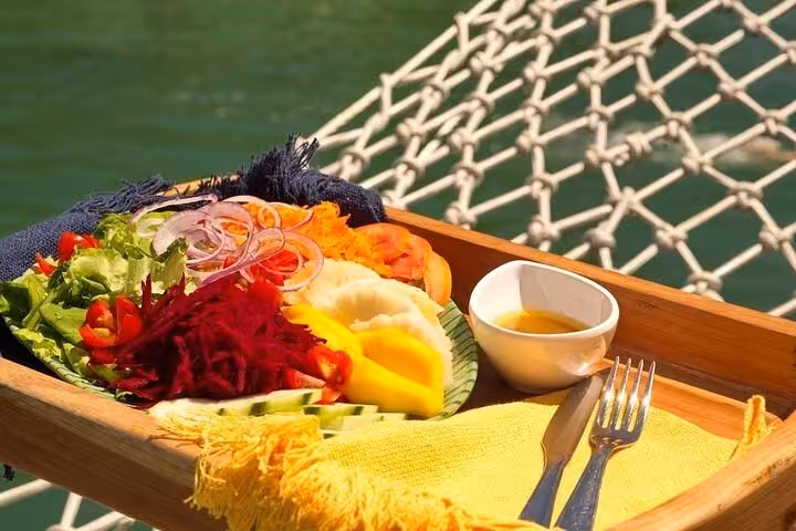 A vibrant tropical lunch with fresh fruits and vegetables served on a boat tour with Paraty Tours, highlighting onboard dining.