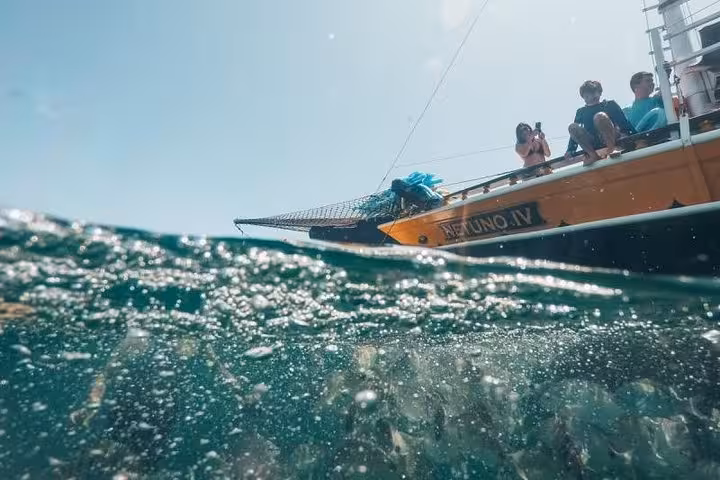 Tourists on a boat capturing ocean views, highlighting the excitement of a boat tour adventure and sea exploration.